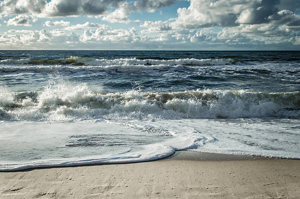 Beach with white water waves At the coast of Westerland (Sylt - Germany). german north sea region stock pictures, royalty-free photos & images