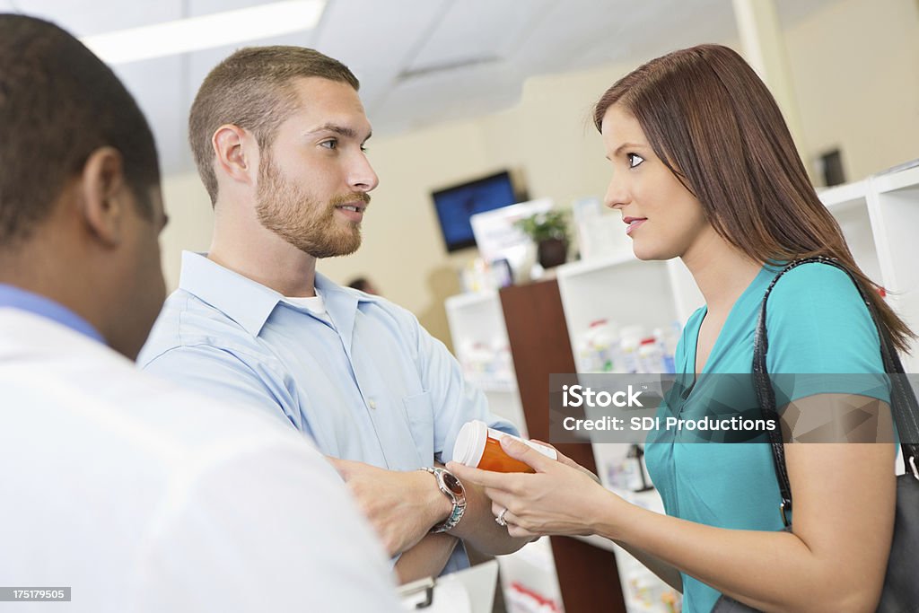 Esposo y esposa estar en desacuerdo sobre medicamentos de venta con receta en la farmacia - Foto de stock de Adulto libre de derechos