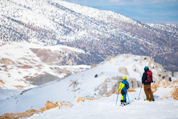 Top view of skiers and snowboarders riding on winter mountain.