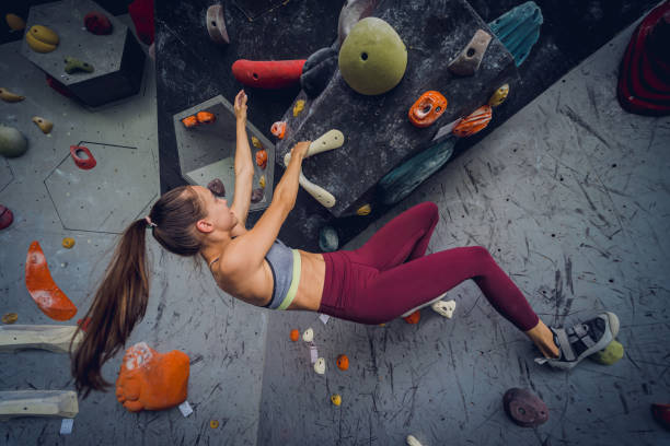 istock A strong female climber climbs an artificial wall with colorful grips and ropes. 1751799631