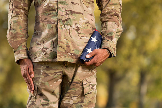 istock Kneeling Soldier Holding an American Flag 175180456