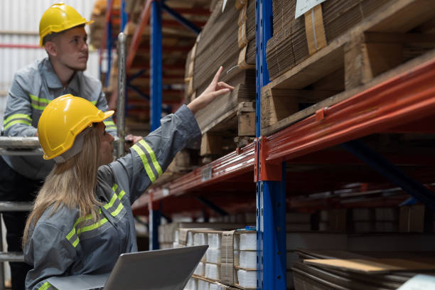 istock Male and female warehouse worker working and discussing in warehouse storage. Warehouse workers inspecting quality of barcodes on shelves pallet 1751806647