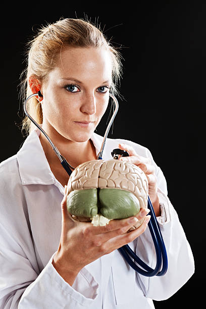 linda loira modelo de cérebro médico examinando com estetoscópio olha - re2012005 vertical looking at camera waist up - fotografias e filmes do acervo