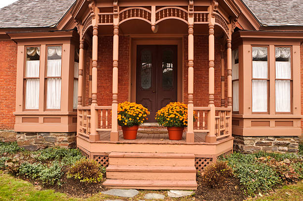 Grand entrance with traditional white door and decorative molding is framed by clean modern columns