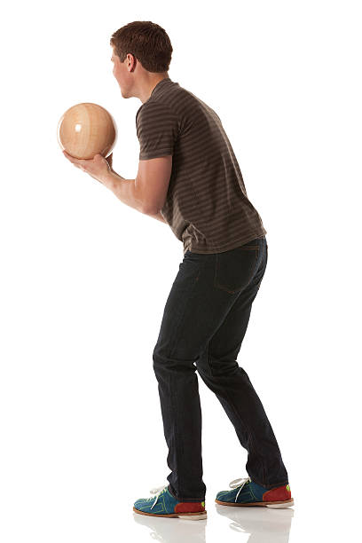 séduisante jeune homme jouant avec une boule de bowling - bowling isolated sportsman vertical photos et images de collection