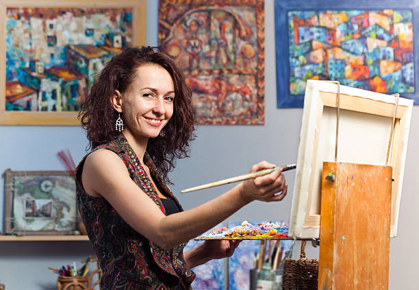 istock Young woman painting in her studio 175181389