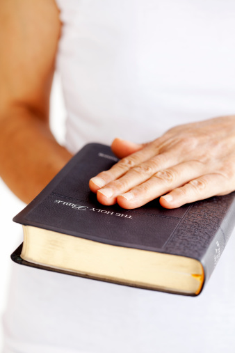 close-up of adult woman swearing on a Bible