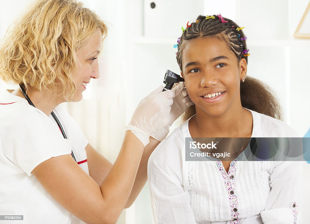 Les jeunes fille au bureau de médecins - Photo de Examen des oreilles libre de droits