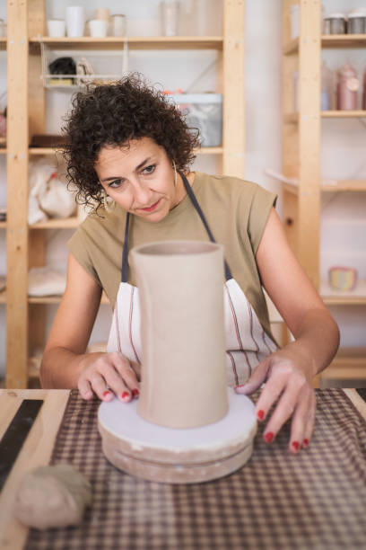 istock Woman analyzing the piece she is creating with clay. 1751826280
