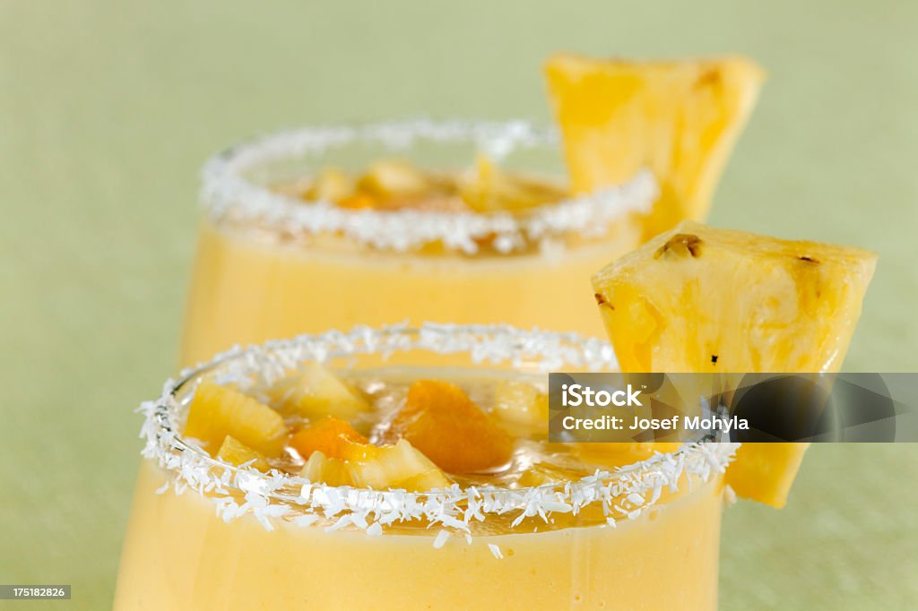 Mango and Pineapple Smoothie Two glasses of mango and pineapple smoothies. Selective focus, shallow DOF. Blended Drink Stock Photo