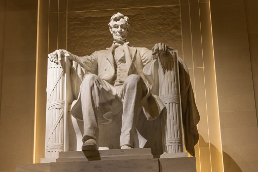 Statue of Abraham Lincoln in the Lincoln Memorial at nighttime in Washington DC, United States