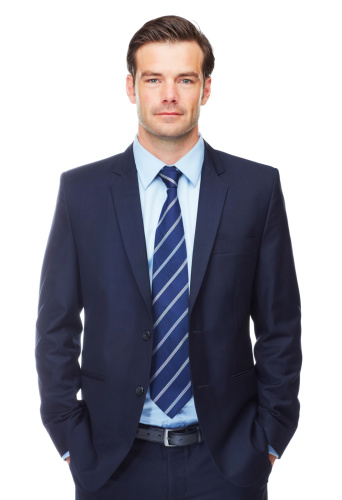 Portrait of a charming businessman dressed in suit and looking at camera isolated on white background