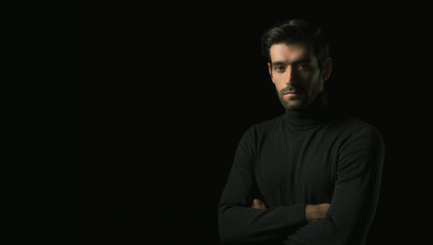 istock Confidence handsome young man with folded arms Attractive businessman look at copy space with crossed arms studio shot standing in the dark room black background Successful young guy portrait 1751836837