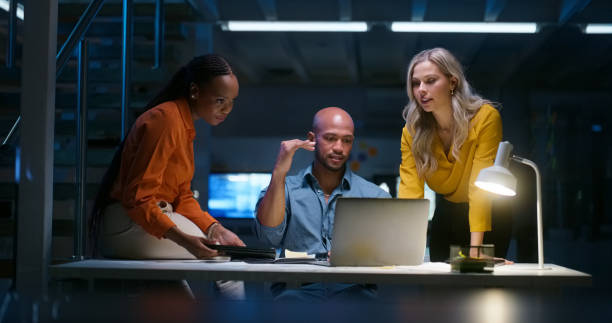 istock Business people, teamwork and laptop in night planning, growth strategy and increase, data analytics or results. Professional analyst, manager or women reading information or stats report on computer 1751843441