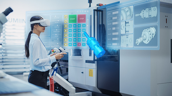 Female Engineer Wearing Virtual Reality Headset and Operating a Heavy Industry Machine with Controllers at a Factory. Digital Visualization of a Technician Configuring Industrial Machinery with VR