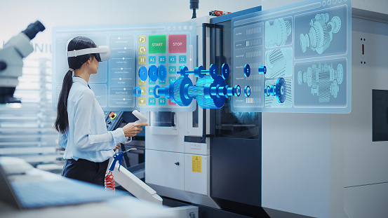 Professional Research and Development Specialist Wearing a Virtual Reality Headset, Managing Settings on an Industrial Machine at a Factory Facility. Digital Hologram Showing Mechanism in Action