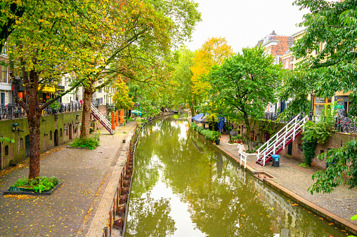 Empty Oudegracht in the city of Utrecht in The Netherlands during fall. The streets on both sides of the canal are almost empty during this early morning.