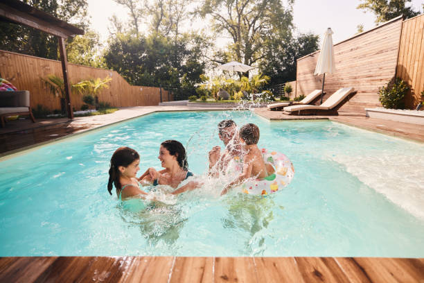 Cheerful family having fun during summer day in the pool.