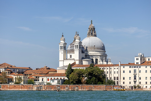 Venice, Italy - September 28, 2023: Baroque church Santa Maria della Salute at the Grand Canal, view from Giudecca Canal. It was built in the 17th century as a votive thanksgiving after the plague epidemic