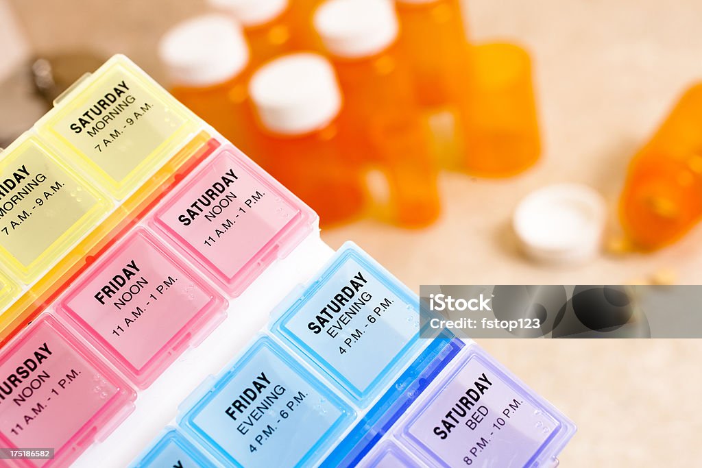 Píldora dispensador con los frascos vacíos en el fondo. - Foto de stock de Medicamento libre de derechos