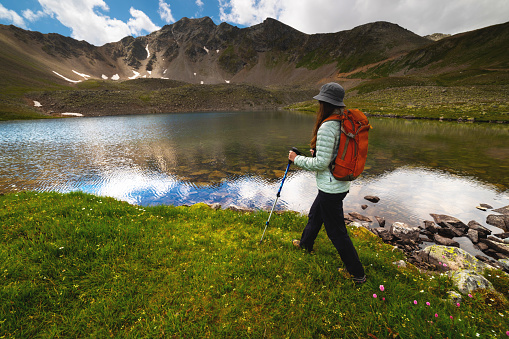 Man traveler walking along beautiful views of mountains and lakes. A woman goes on a trip and walks in the mountains. Beautiful view.