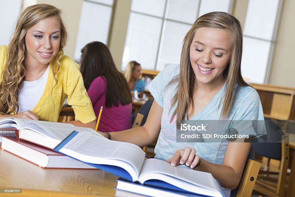 Школа девочек, обучающихся вместе в библиотеке - Стоковые фото Американская культура роялти-фри