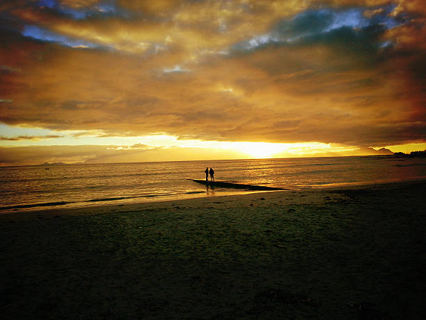istock Golden sunset watched from pier by silhouetted couple 175187419
