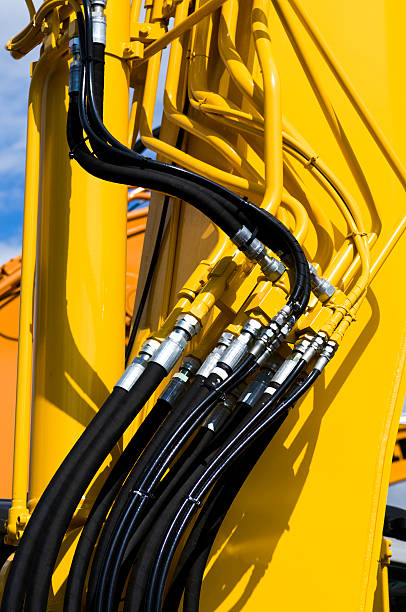 Close-up of bound black wires connecting yellow machinery stock photo