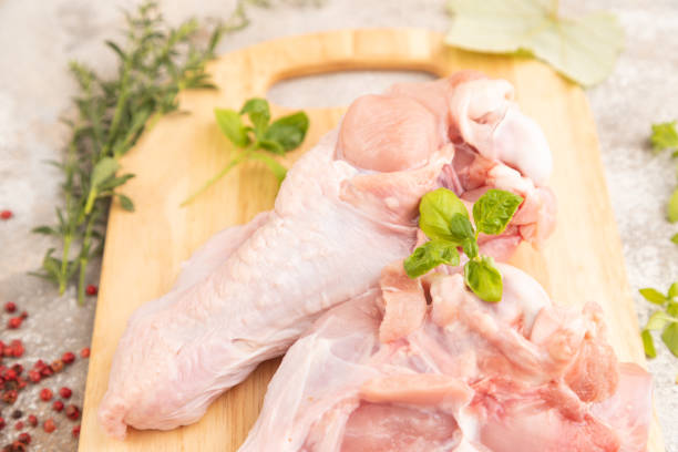 istock Raw turkey wing on a wooden cutting board on a brown concrete background. Side view, selective focus 1751877312