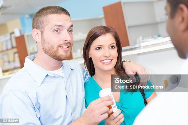 Marito E Moglie In Farmacia Parlando Con Il Farmacista Prescrizione - Fotografie stock e altre immagini di Accudire