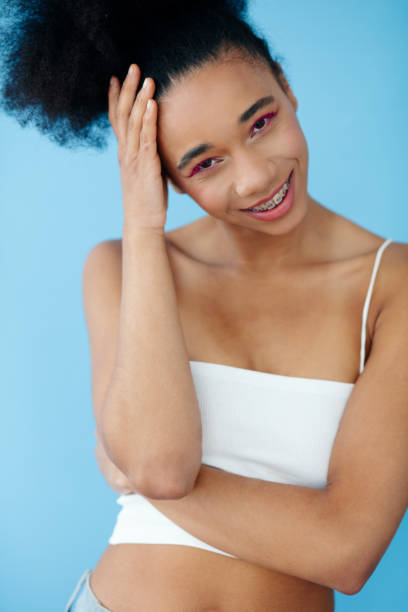 istock Young beautiful girl posing in studio over blue background. 1751883789