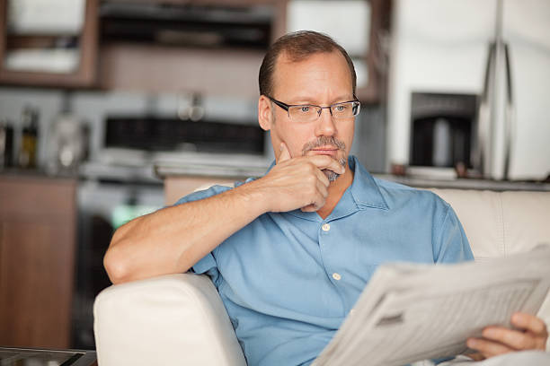 istock Contemplative Mature Man Reading Newspaper At Home 175188398