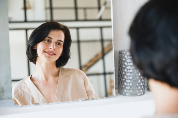istock Woman looking at reflection in mirror and smile 1751884379