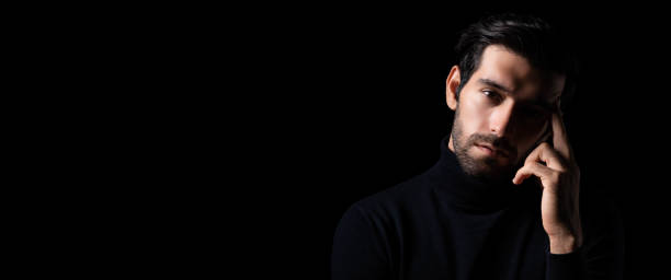 istock Planning thinking handsome young beared man portrait Attractive bearded confident guy planning and looking at copy space Smart man thinking in the dark room Cool man get good idea imagination 1751886233