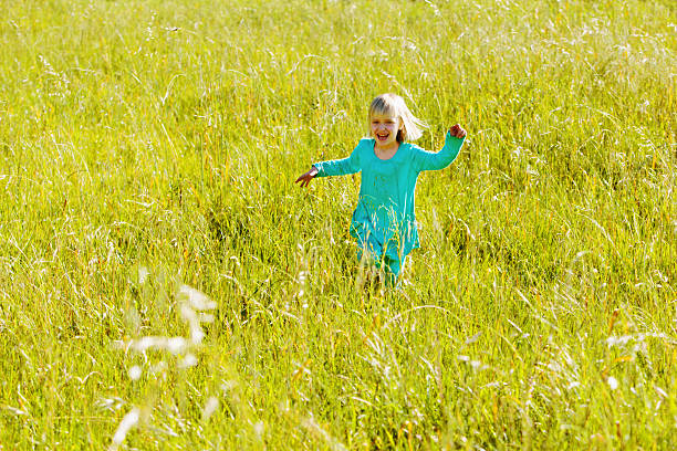 little girls play in the summer on a green meadow with water pistols. High quality photo