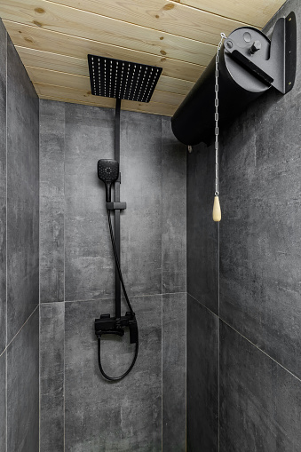 Black large square shower head, rain watering can in the bathroom, modern design of the black wall shower tap.