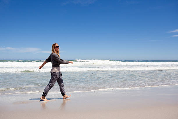 istock young woman walks on beach 175189467