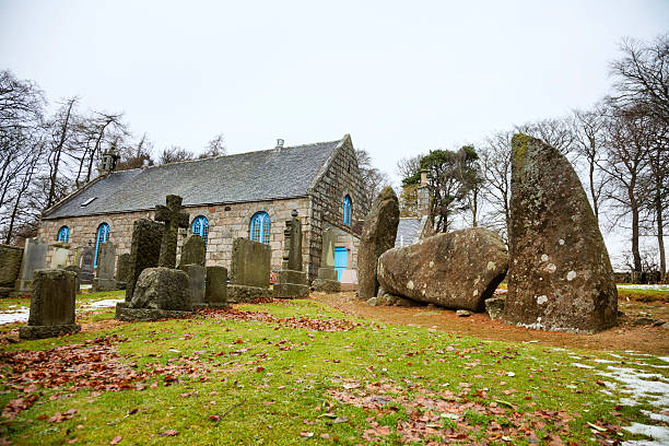 pagan steine stehen neben einer christlichen kirche. - midmar stock-fotos und bilder