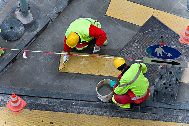 Works in the street Two persons working in repairing the sidewalk of a street public utility stock pictures, royalty-free photos & images