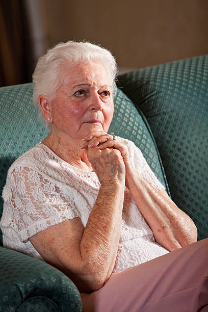 istock Worried senior woman sitting on couch 175190591