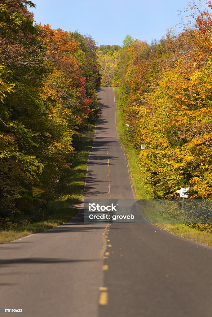 Fall colors on a rural roadway in Michigan. Michigan's upper peninsula rural road with fall colors. Autumn Stock Photo