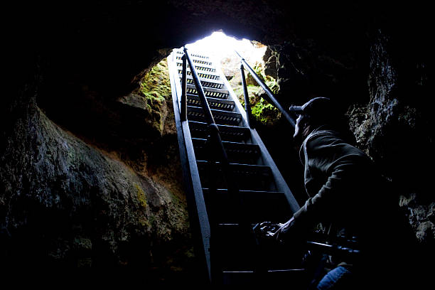 Photographer exiting Golden Dome Cave at Lava Beds National Monument in California, USA.