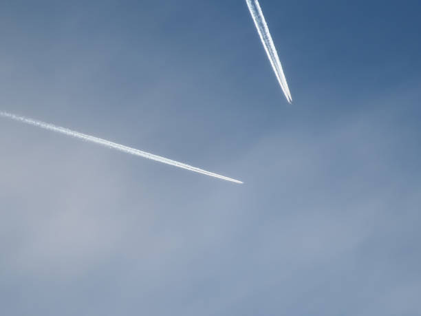 istock Airplane trail in the blue sky with white clouds and contrail. 1751908687