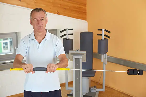 60 years old man in a gym with a swingstick