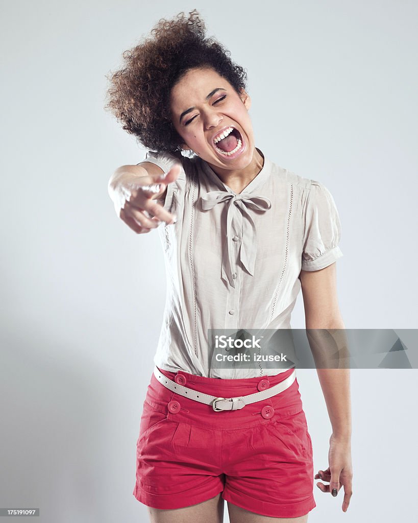 Teenage rebellion Portrait of teenaged girl pointing with index finger and screaming at the camera. Studio shot, grey background. 18-19 Years Stock Photo