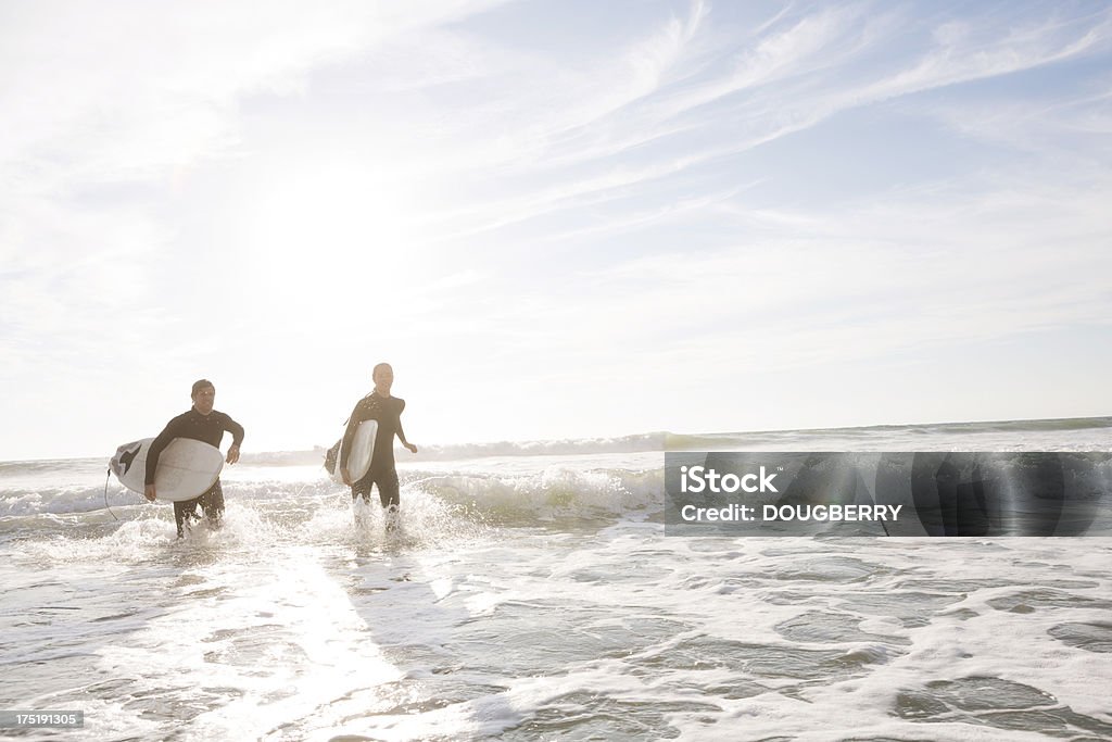 Surfing Man and woman in the ocean Please see similar images in my portfolio: 20-24 Years Stock Photo