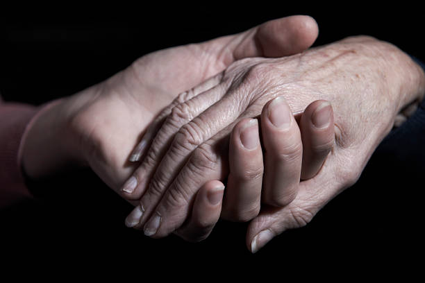 istock Young Woman Holding Old Woman's Hand Against Black Background 175191465