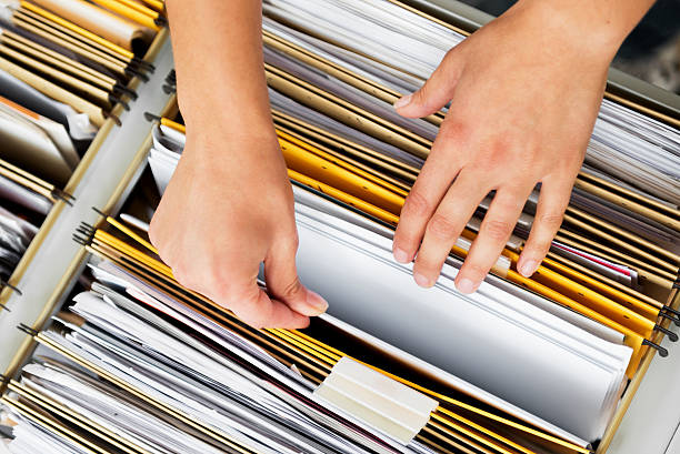 Searching In File Cabinet Close-up of hands searching in a file cabinet filing cabinet stock pictures, royalty-free photos & images