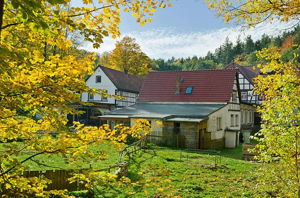 Old framehouse in autumn. This house is an old mill in  Thuringia, Germany. A very known hiking area - Muhltal in the near of Eisenberg. Here shown the Naupoldsmuhle - today a restaurant.