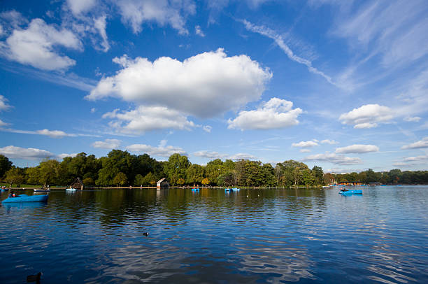 Paddle boats populate the Serpentine in Hyde Park in central London on a sunny autumn day
